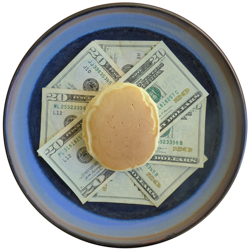 A pancake sits atop a pile of money.